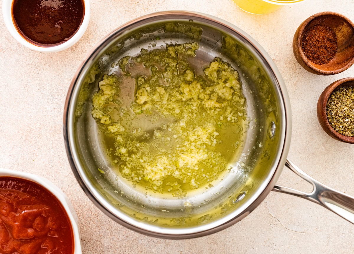 Diced onions and garlic sautéing in a pot with oil.