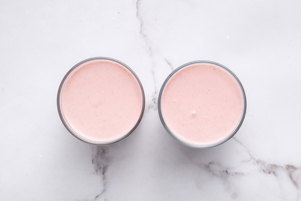 The strawberry cottage cheese mixture divided between two glasses.