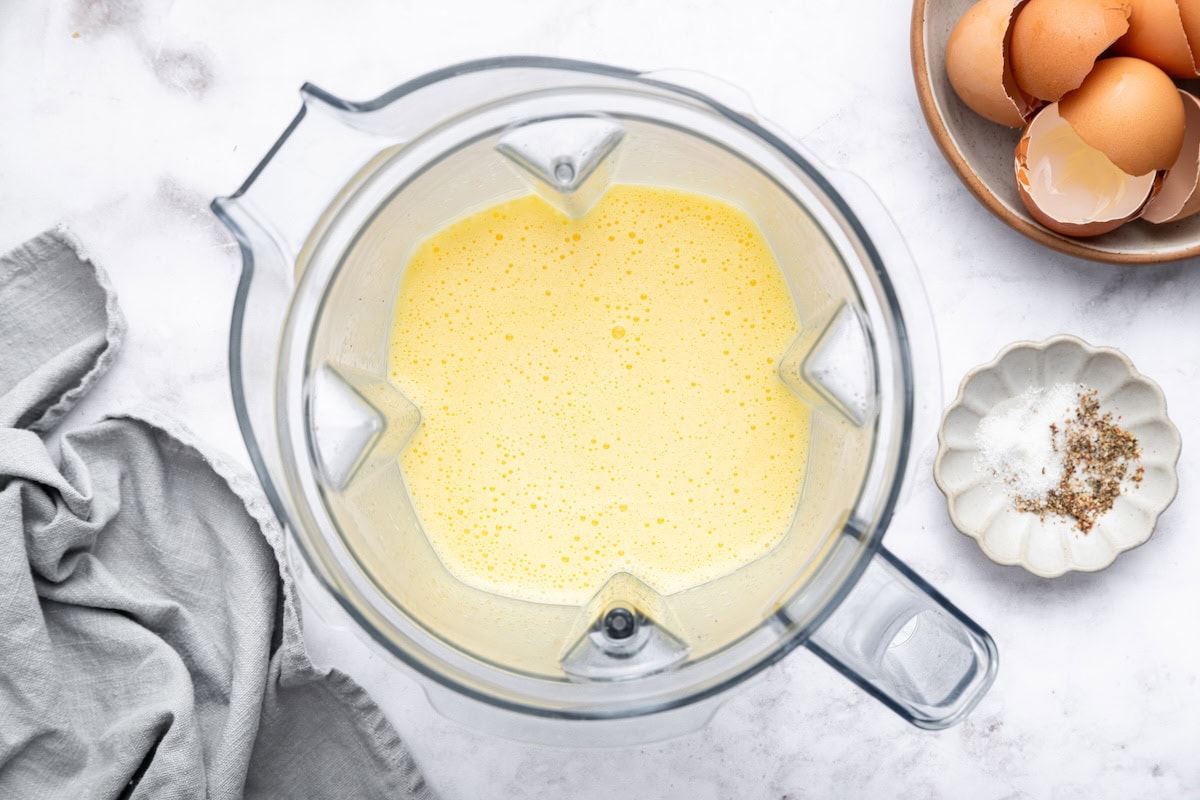 The cottage cheese egg bite mixture blended up in the base of a blender.