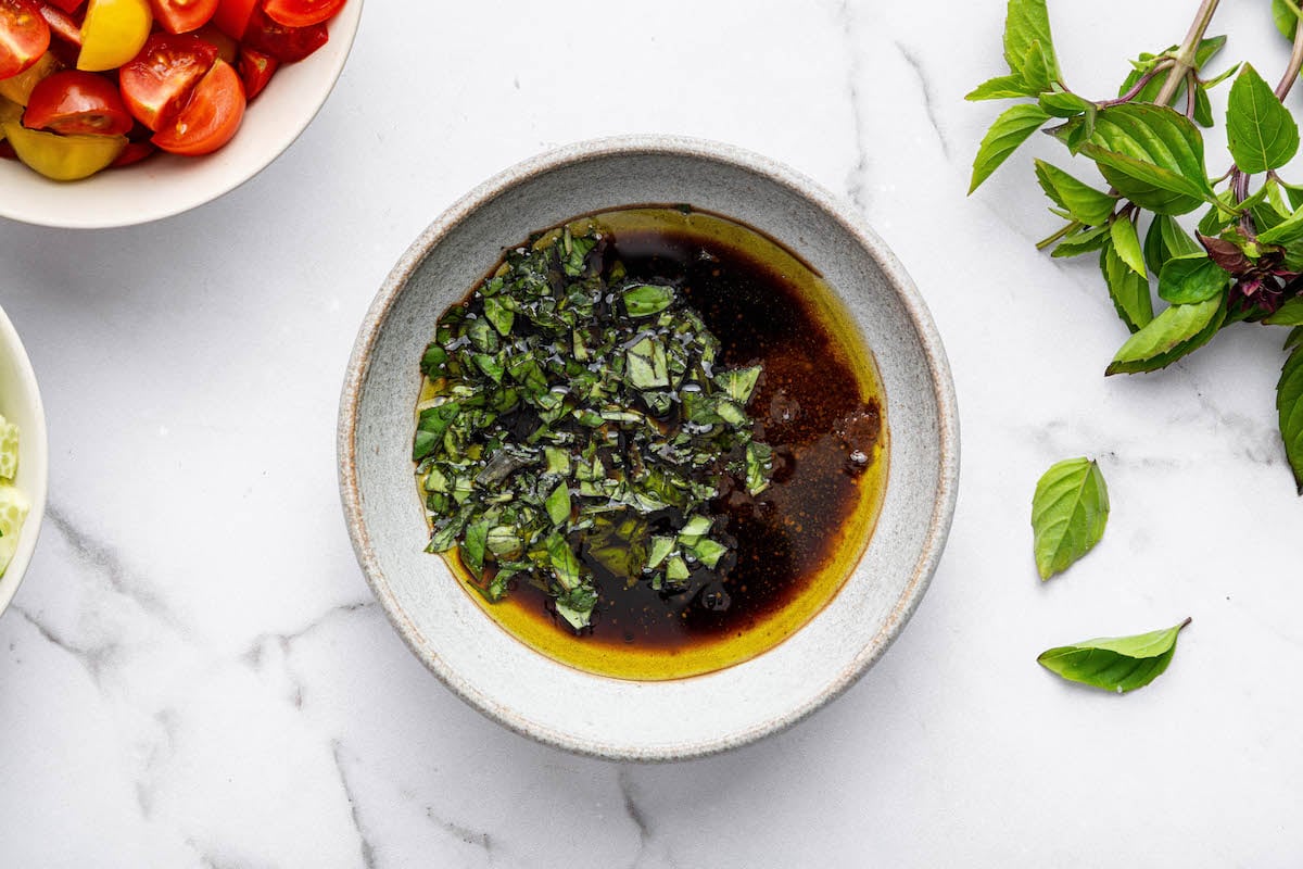 The basil balsamic dressing ingredients in a small bowl for the healthy pasta salad.