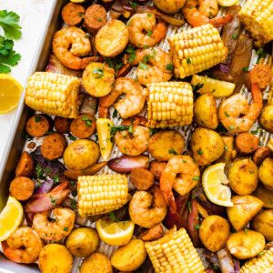 Sheet pan shrimp boil with golden potatoes, shrimp, sausage, and corn.