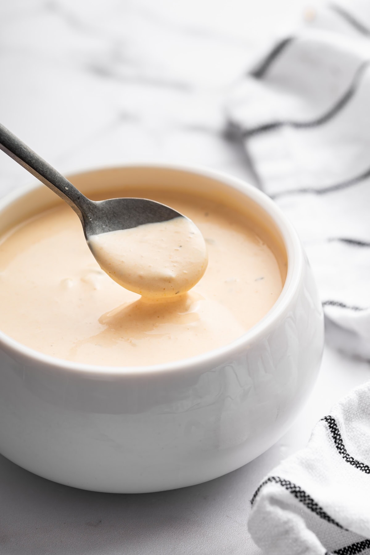 A spoonful of Big Mac sauce being lifted from a bowl