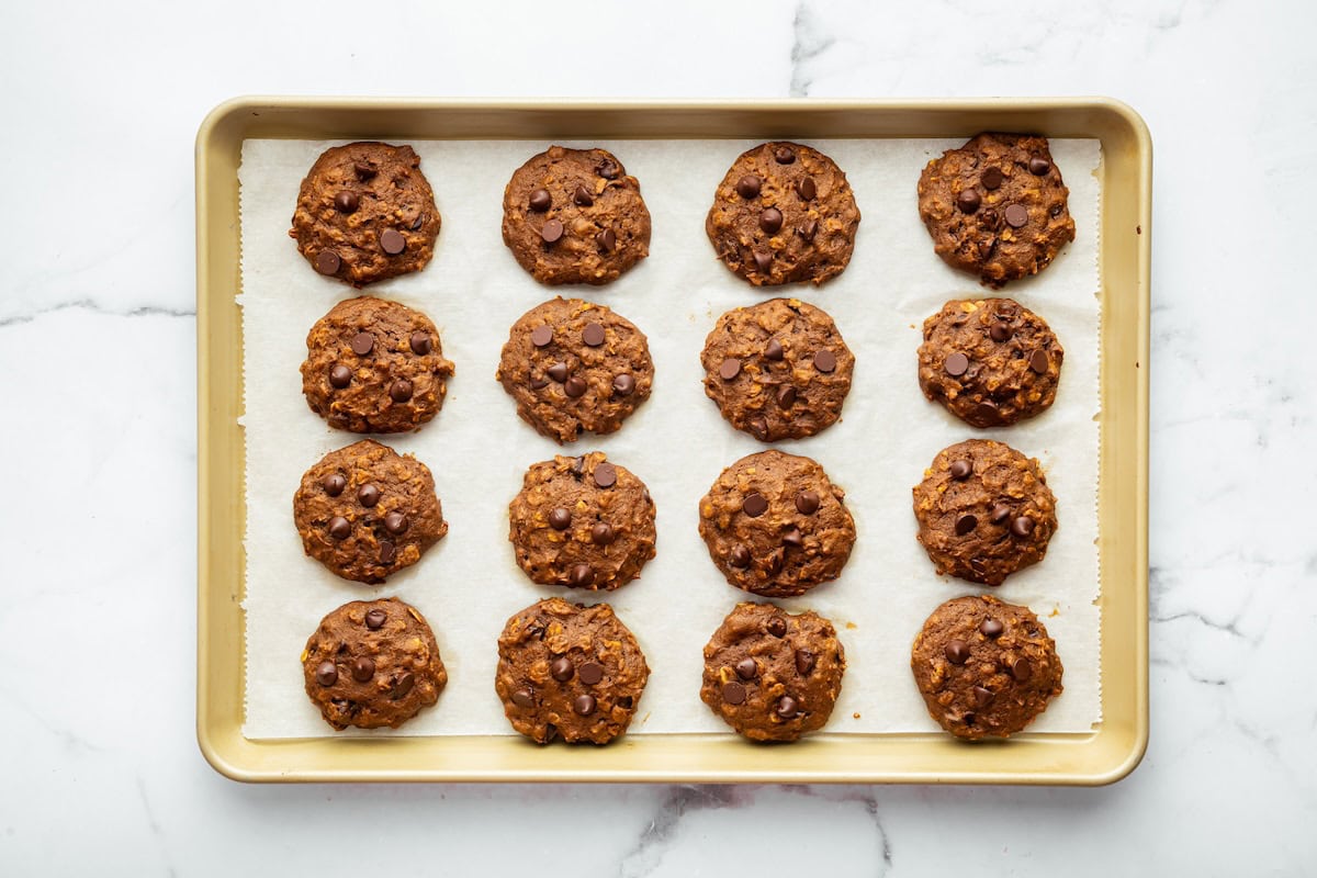 Pumpkin oatmeal cookies on a baking sheet lined with parchment paper.