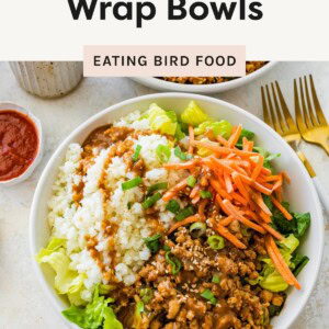 Bowl of chicken lettuce wrap with cauliflower rice, carrots, ground chicken, and sauce.