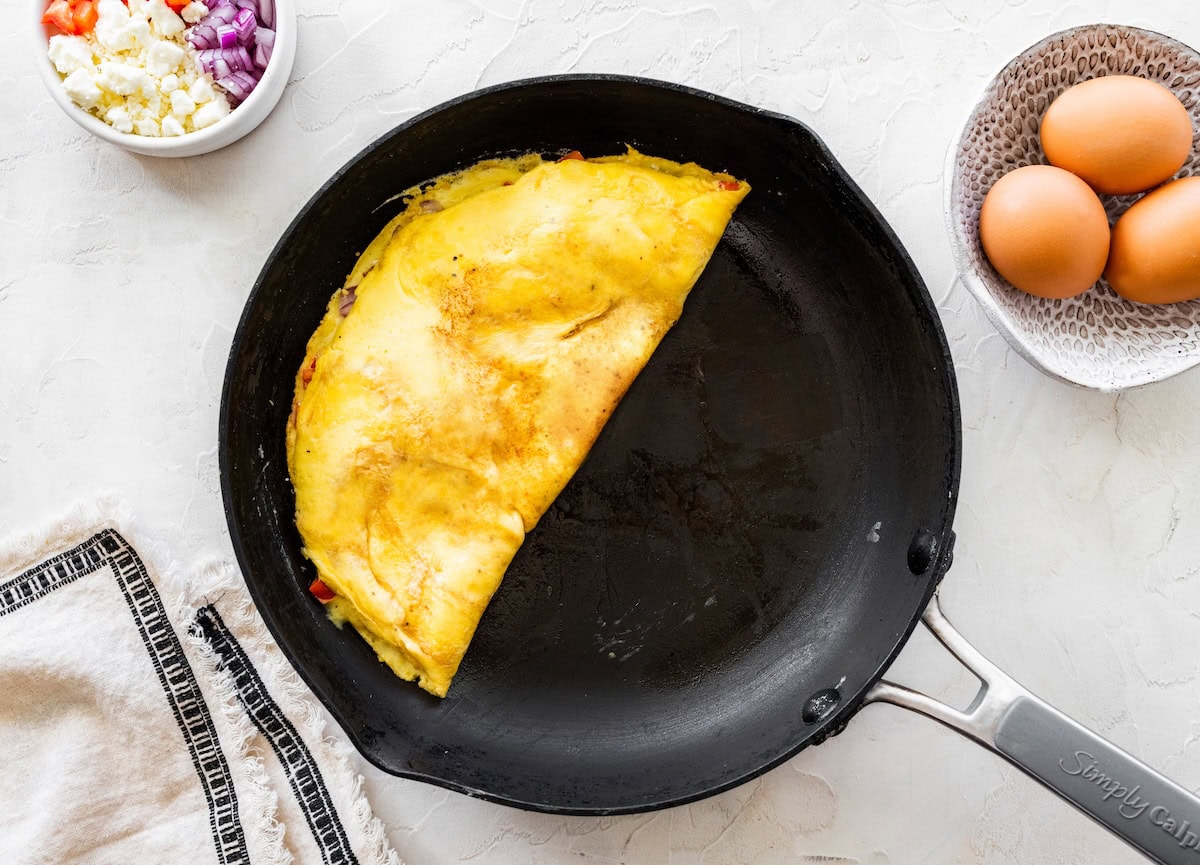 Omelette folded in a skillet Omelette folded in a skillet with golden edges and peppers tucked inside.