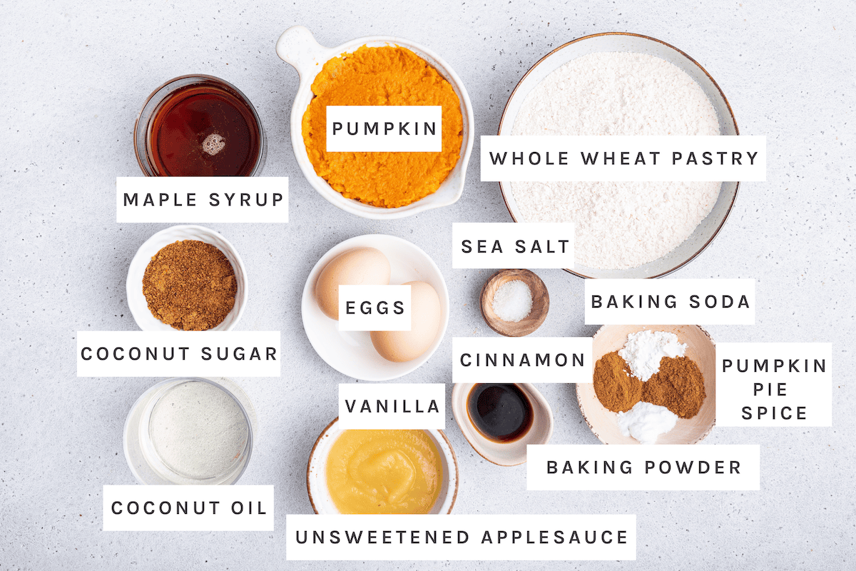 Ingredients measured out to make Pumpkin Banana Bread: whole wheat pastry flour, baking powder, pumpkin pie spice, baking soda, cinnamon, sea salt, vanilla, pumpkin, eggs, unsweetened applesauce, maple syrup, coconut sugar and coconut oil.