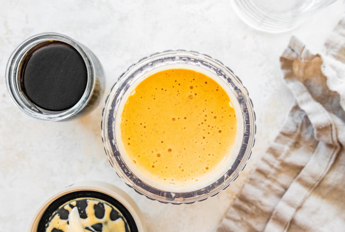 Blended pumpkin spice latte mixture in a glass blender jar.