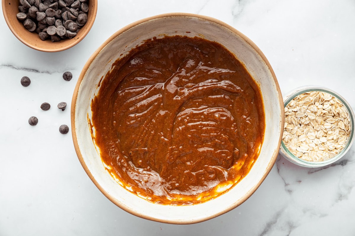 Smooth pumpkin oatmeal cookie batter in a mixing bowl before adding oats and chips.