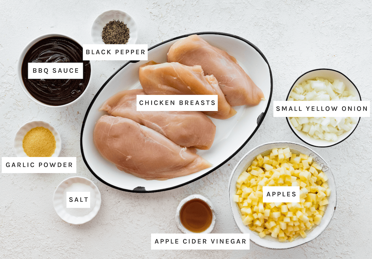 Ingredients for the slow cooker apple BBQ chicken: Chicken breasts, small yellow onion, apples, BBQ sauce, vinegar, garlic powder, salt and black pepper.