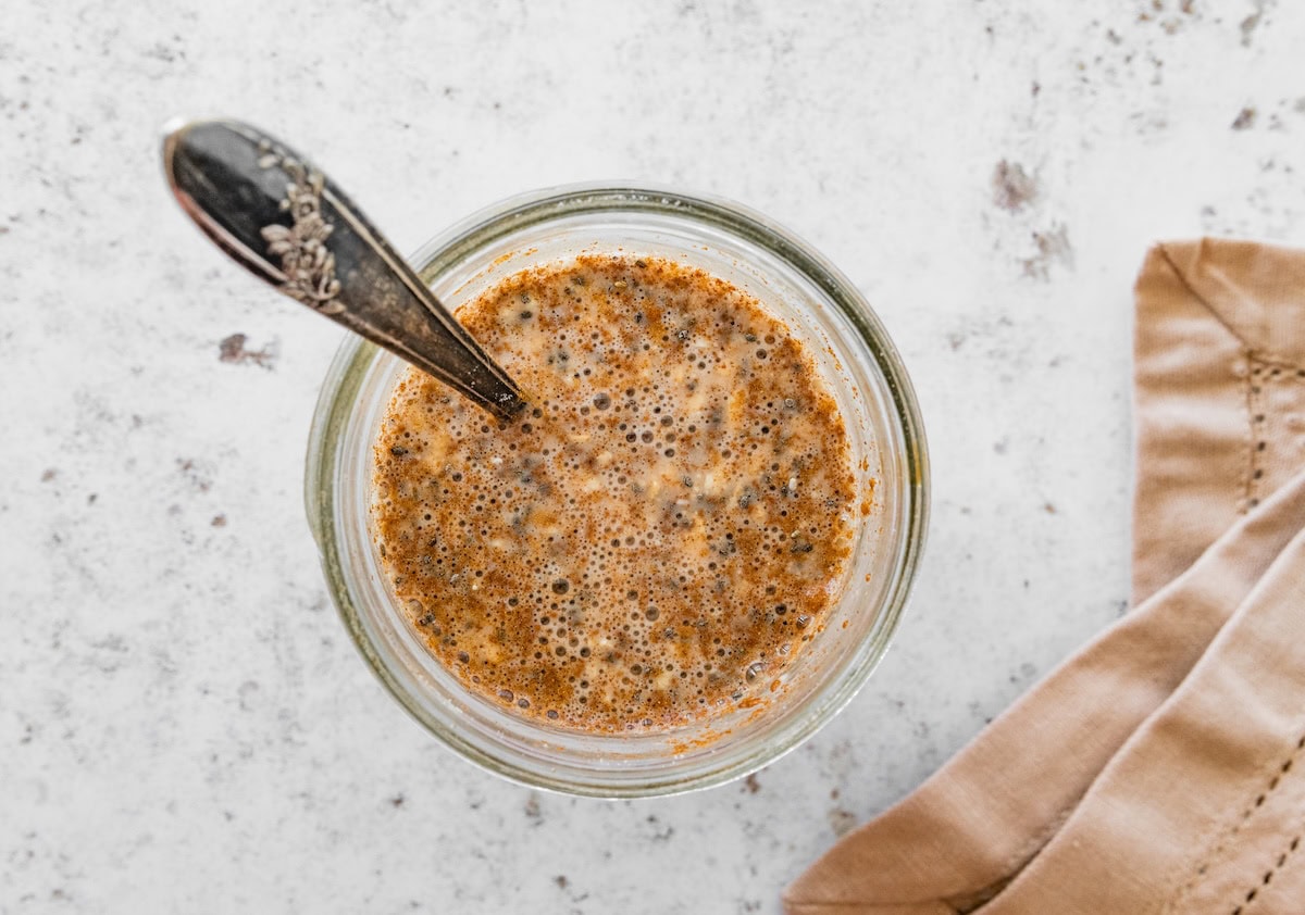 Jar of snickerdoodle overnight oats Jar of snickerdoodle overnight oats being stirred with a spoon.