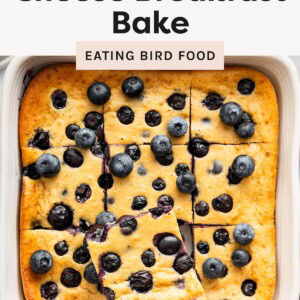 Overhead view of a blueberry cottage cheese breakfast bake cut into squares with one piece lifted on a spatula.