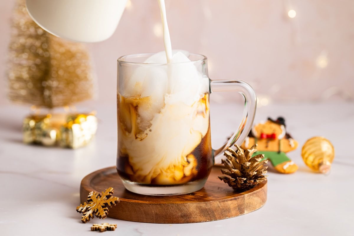 Almond milk being poured Almond milk being poured into an iced sugar cookie latte, creating a swirled creamy effect.
