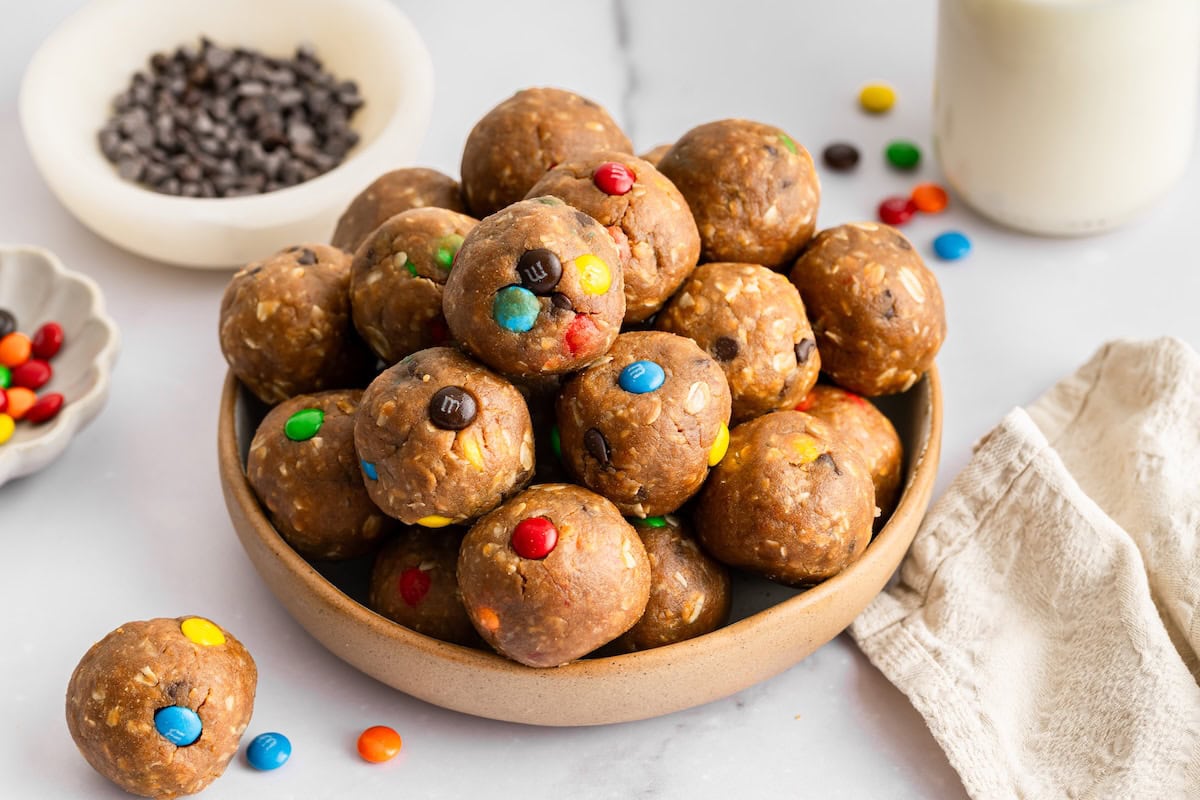 Monster Cookie Protein Balls Bowl of monster cookie protein balls made with oats, peanut butter, chocolate chips, and M&M’s.