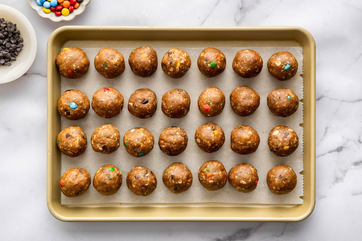cookie protein balls Monster cookie protein balls arranged on a baking sheet for easy no bake meal prep.