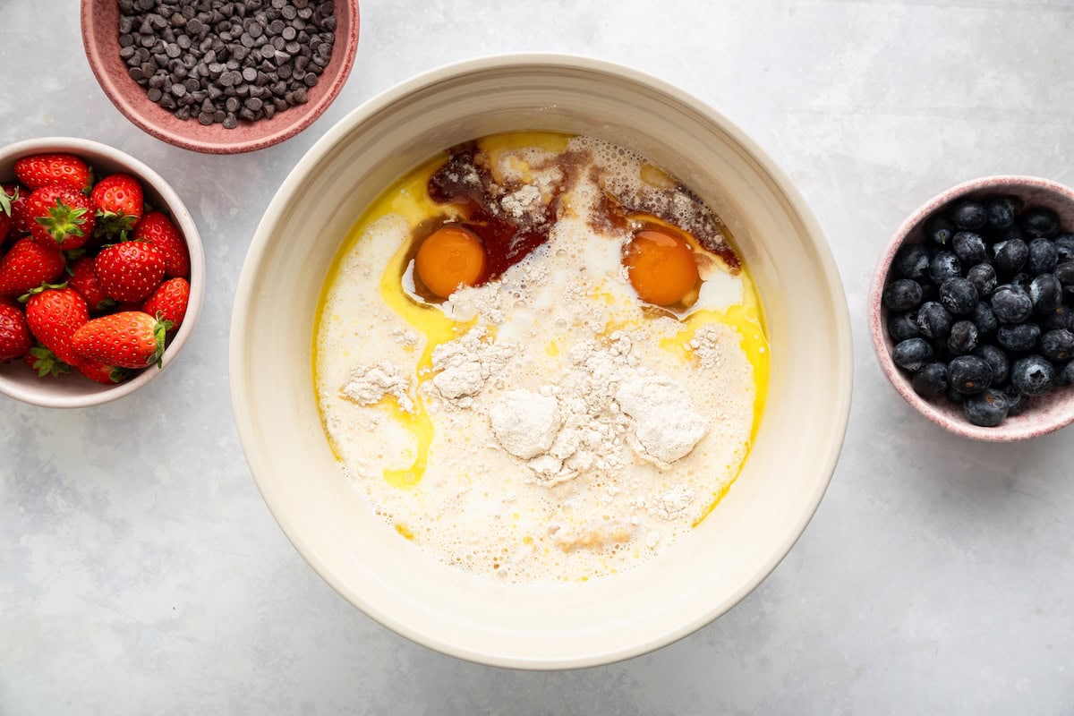 Mixing Kodiak pancake batter with eggs, milk, and vanilla in a bowl.