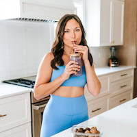 Woman in blue workout set with a smoothie.