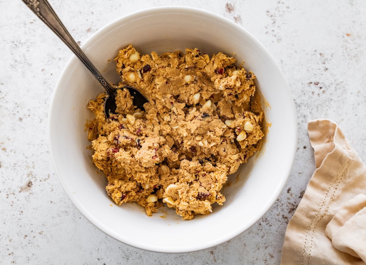 Cranberry orange protein ball dough in a white bowl before being rolled into balls.