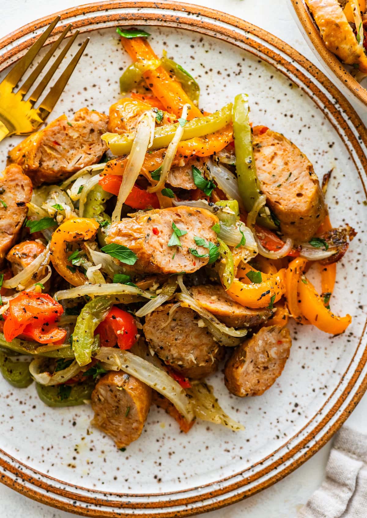 Plate of chicken sausage with roasted peppers and onions tossed together for serving.