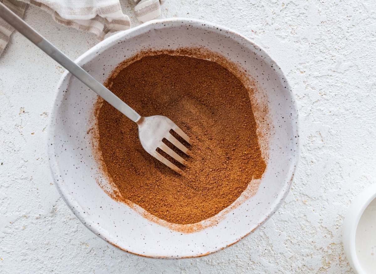 Bowl of cinnamon sugar mixture Bowl of cinnamon sugar mixture with a fork ready for coating the protein balls.