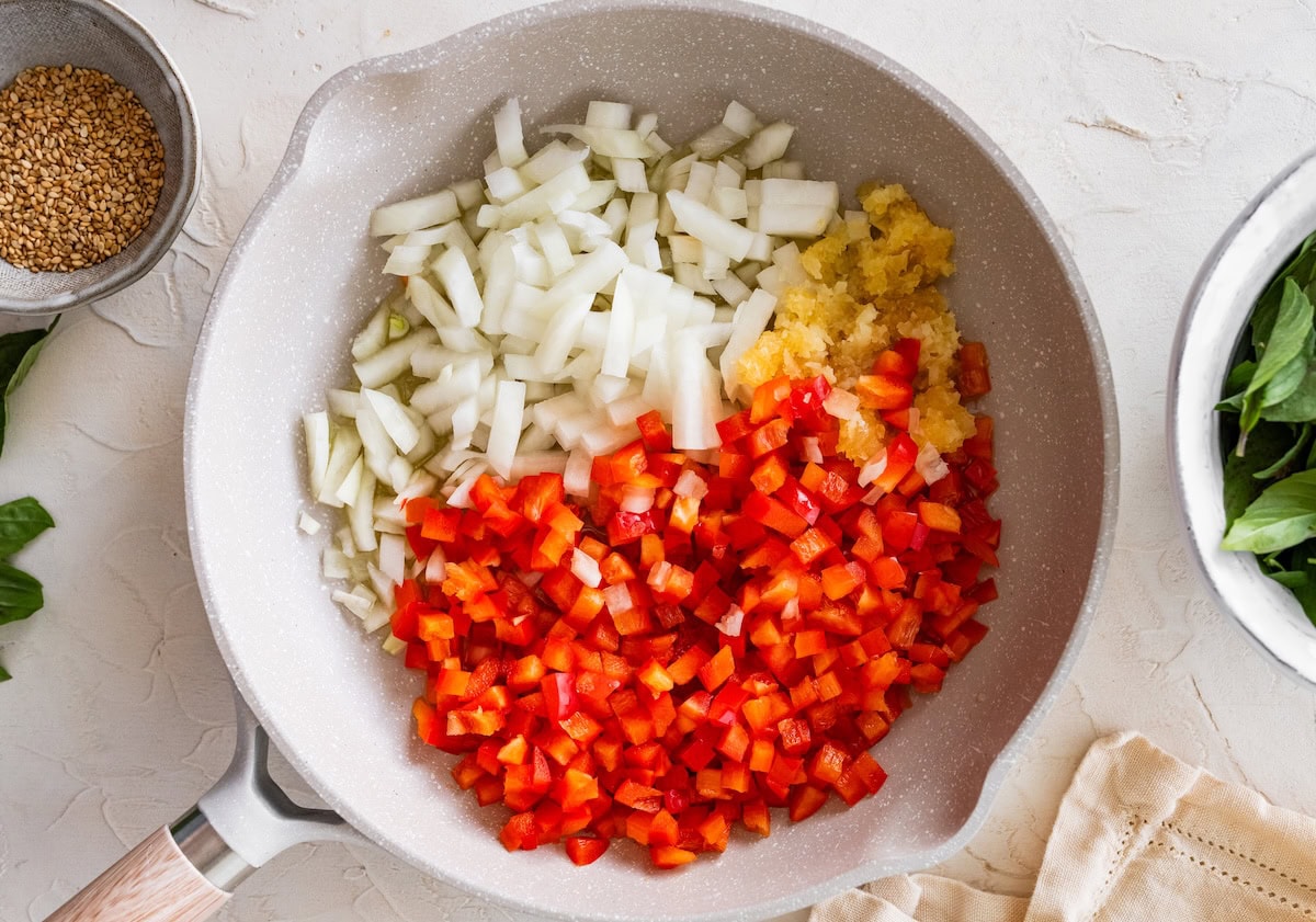 Diced ingredients Diced onion, bell pepper and minced garlic added to a skillet before sautéing.