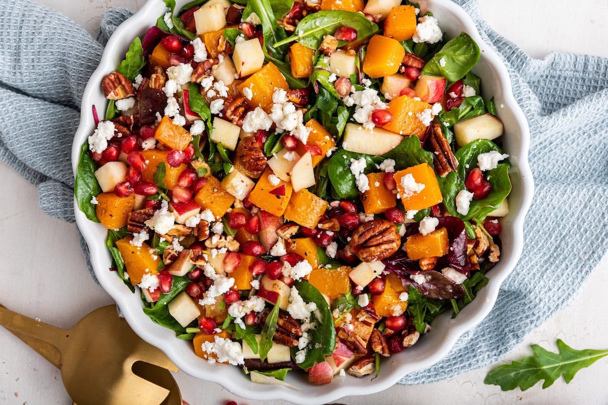 Salad topped with roasted butternut squash, pomegranate, goat cheese, pecans and apples.