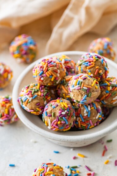 A bowl full of birthday cake protein balls with colorful sprinkles.