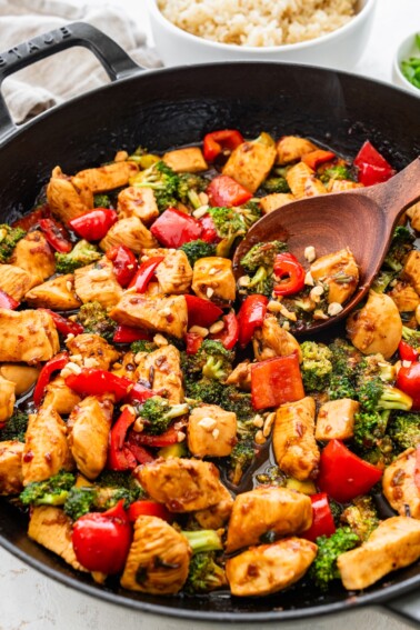 Kung pao chicken stir fry with vegetables and sauce in a skillet, ready to serve.