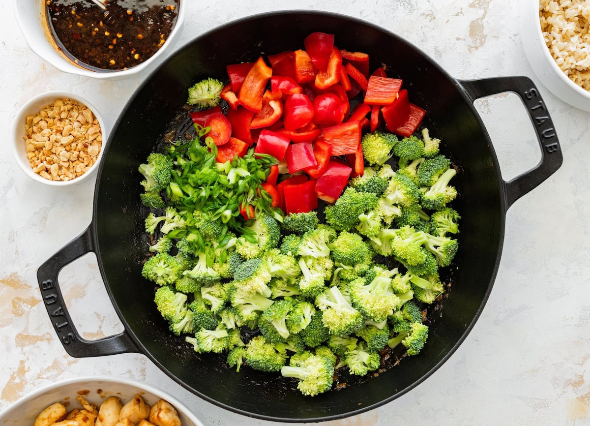 Chopped bell peppers and broccoli Chopped bell peppers and broccoli cooking together in a large skillet.