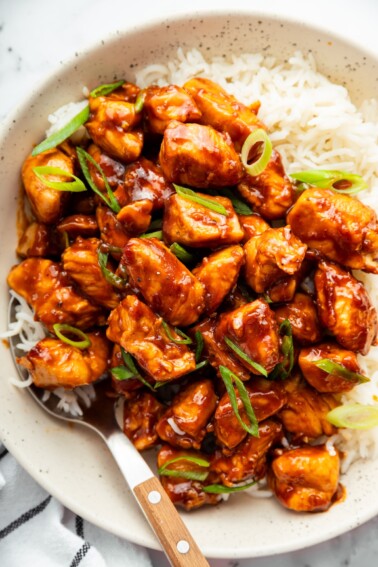Sweet and savory glazed chicken served over fluffy rice in a bowl.