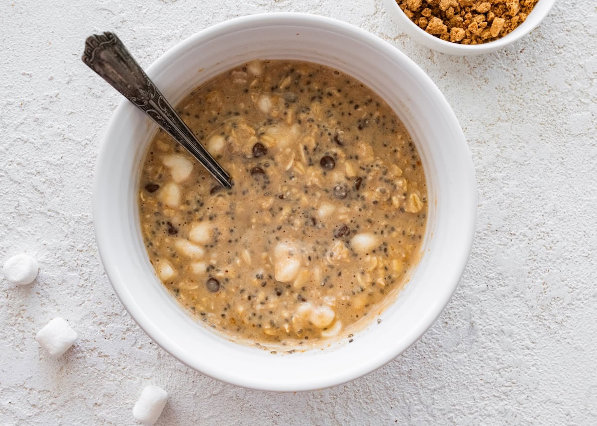 A large mixing bowl with ingredients soaking used for s'mores overnight oats.