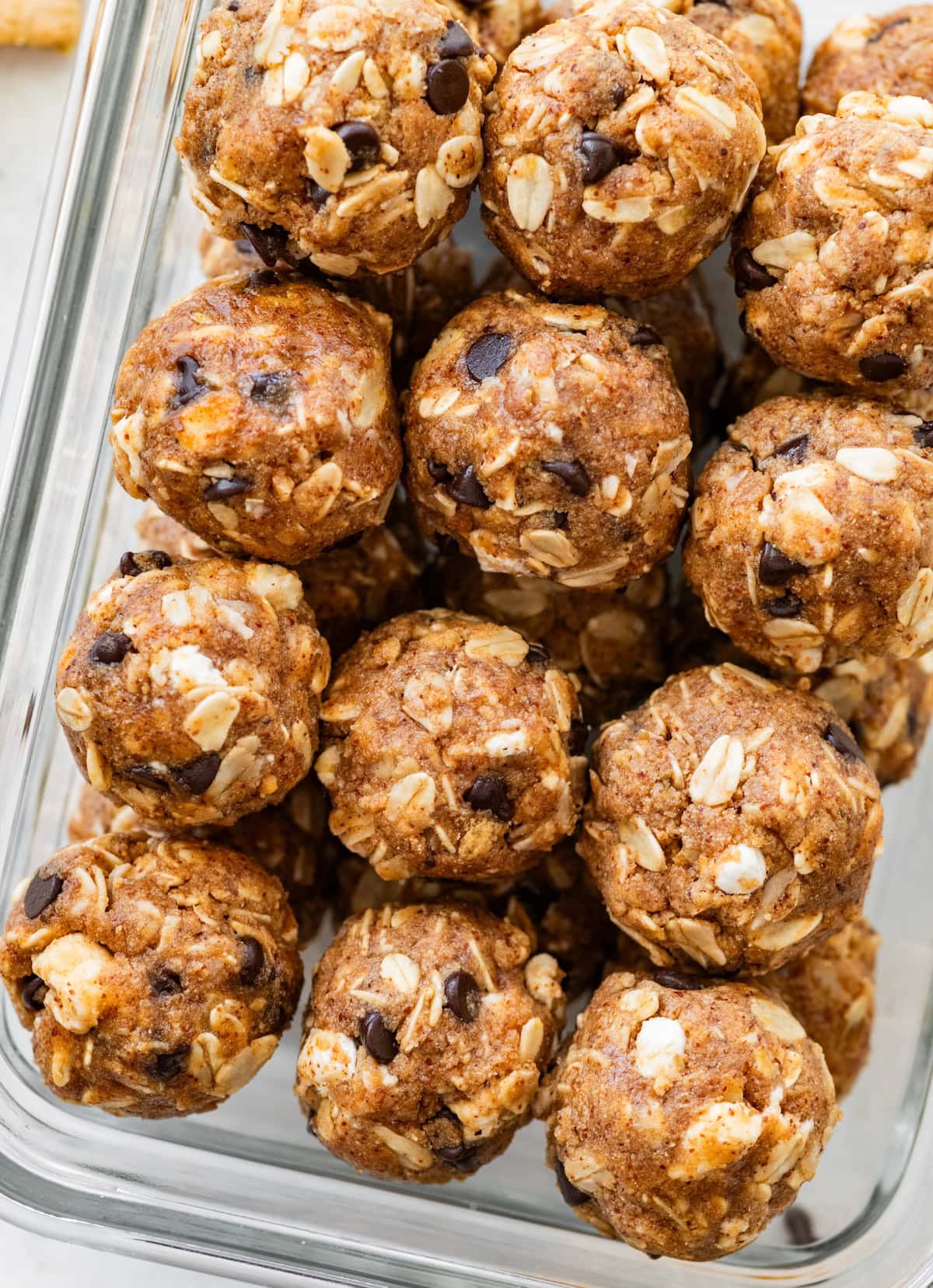 S’mores protein balls stacked in a glass storage container.
