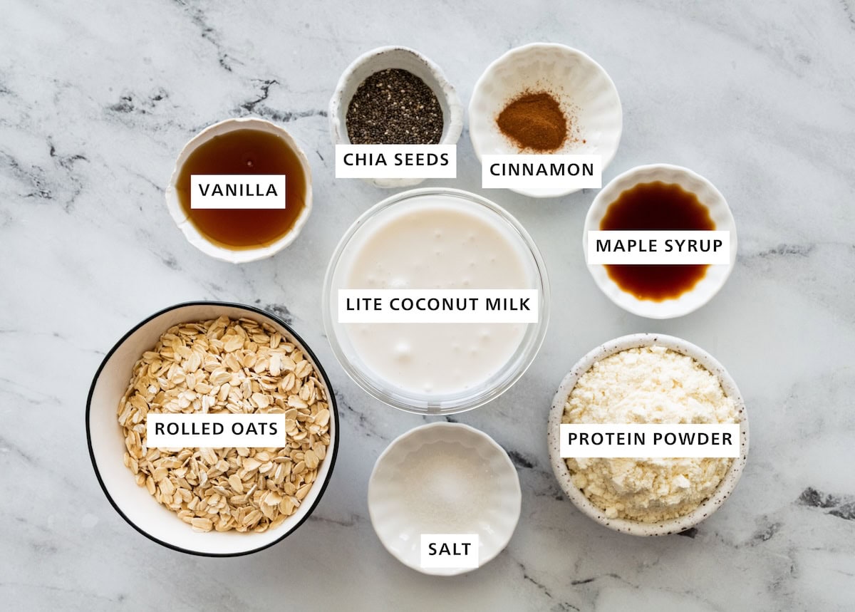 Ingredients for coconut overnight oats: rolled oats, lite coconut milk, protein powder, salt, maple syrup, cinnamon, chia seeds and vanilla.