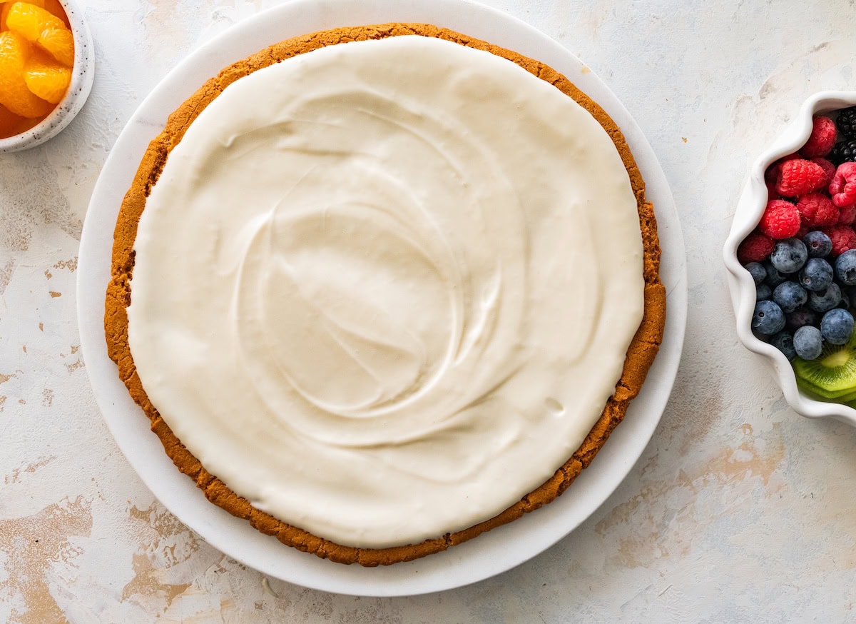 Sugar cookie crust topped with cream cheese frosting before adding fruit.