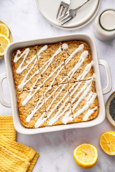 Lemon poppy seed baked oatmeal in pan drizzled with yogurt glaze ready to serve.