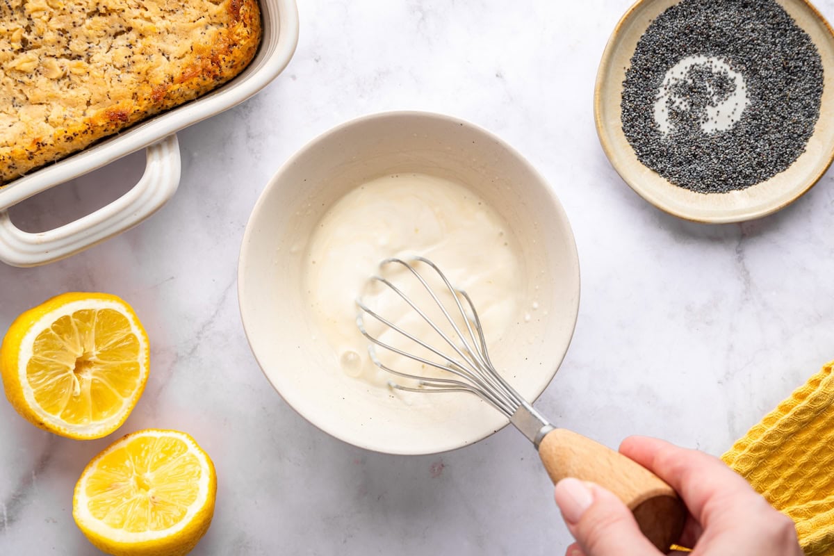 Whisking lemon yogurt glaze in small bowl for baked oatmeal topping.
