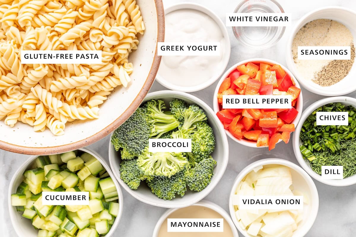 Ingredients measured out to make ranch pasta salad including pasta, veggies, Greek yogurt and herbs.