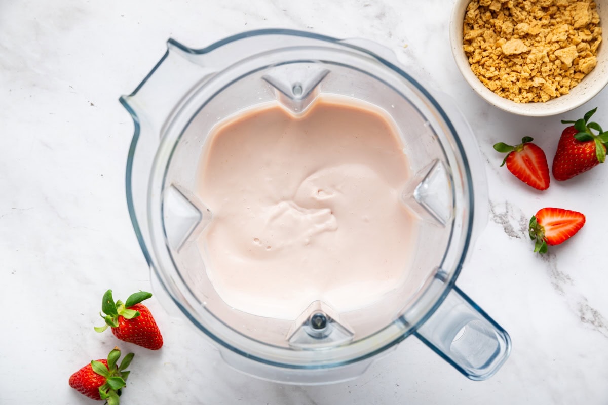 A blended strawberry cheesecake cottage cheese ice cream mixture in a blender.
