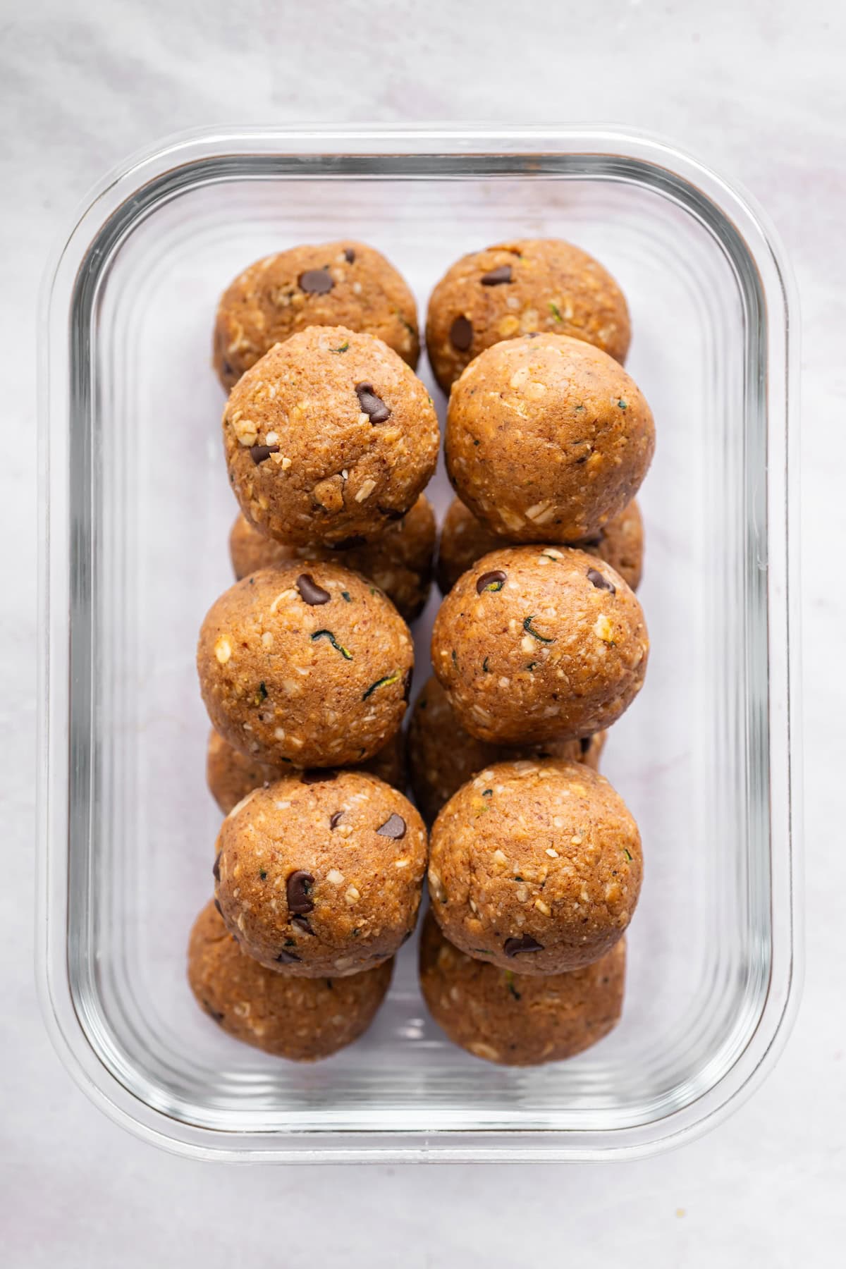 Zucchini protein balls in a glass storage container.