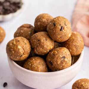 Zucchini protein balls stacked on top of each other in a small ceramic bowl.