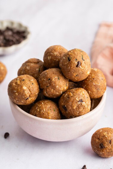 Zucchini protein balls stacked on top of each other in a small ceramic bowl.
