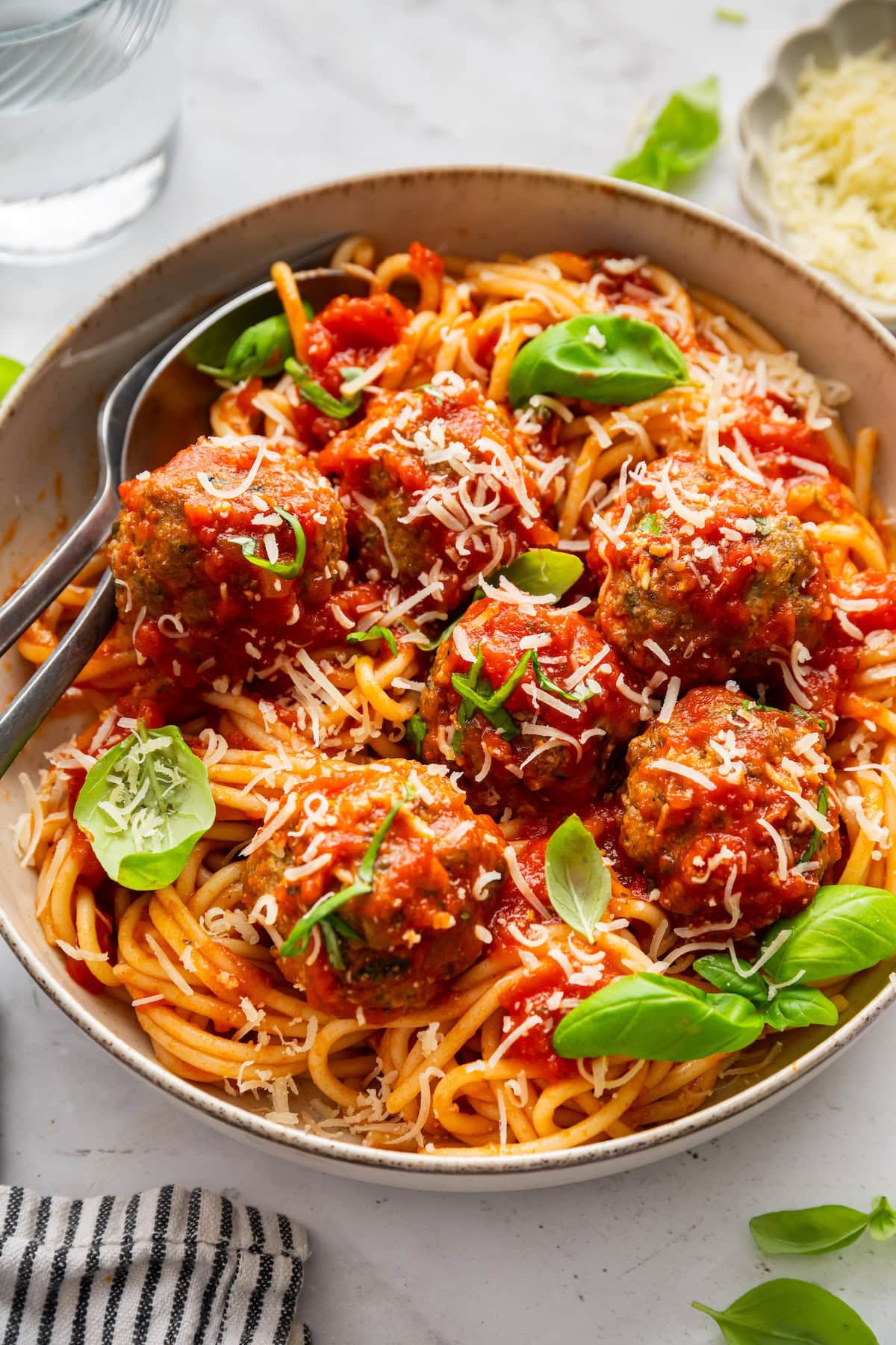 Zucchini meatballs served in a bowl with spaghetti, marinara sauce, fresh basil, and parmesan cheese.