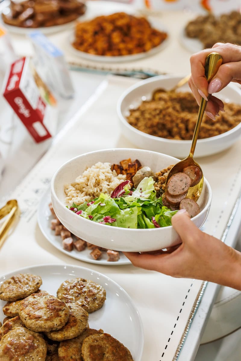 Bowl of rice, greens, sausage, and vegetables being served at a Fresh Air Retreat meal.