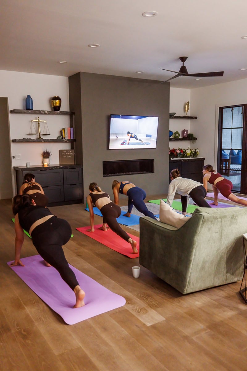 Fresh Air Retreat attendees doing a guided yoga workout in a living room.