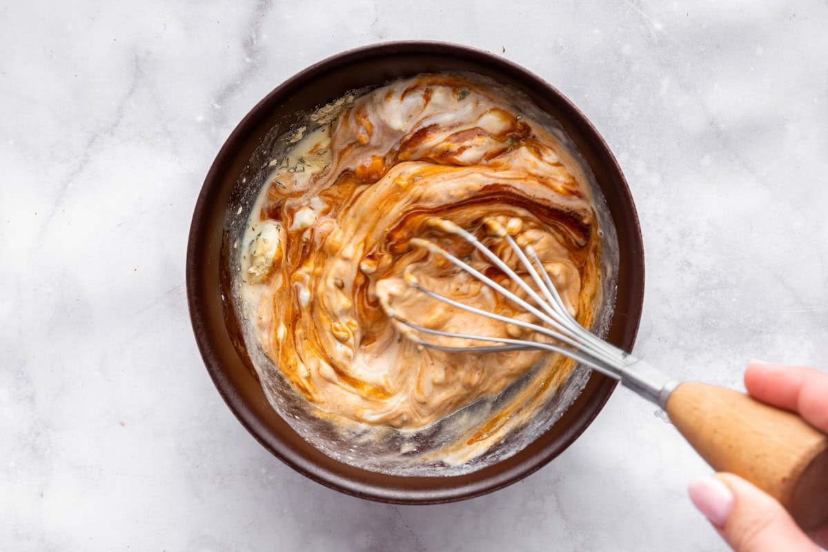 A high protein BBQ ranch dressing being mixed in a bowl.