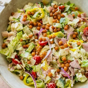 Grinder salad in a large serving bowl with chickpeas, veggies, and deli meats.