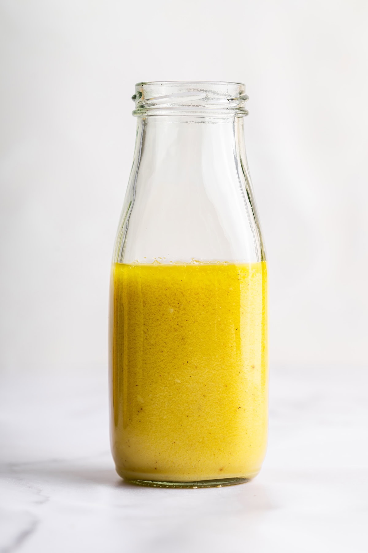 A glass jar with honey mustard dressing.