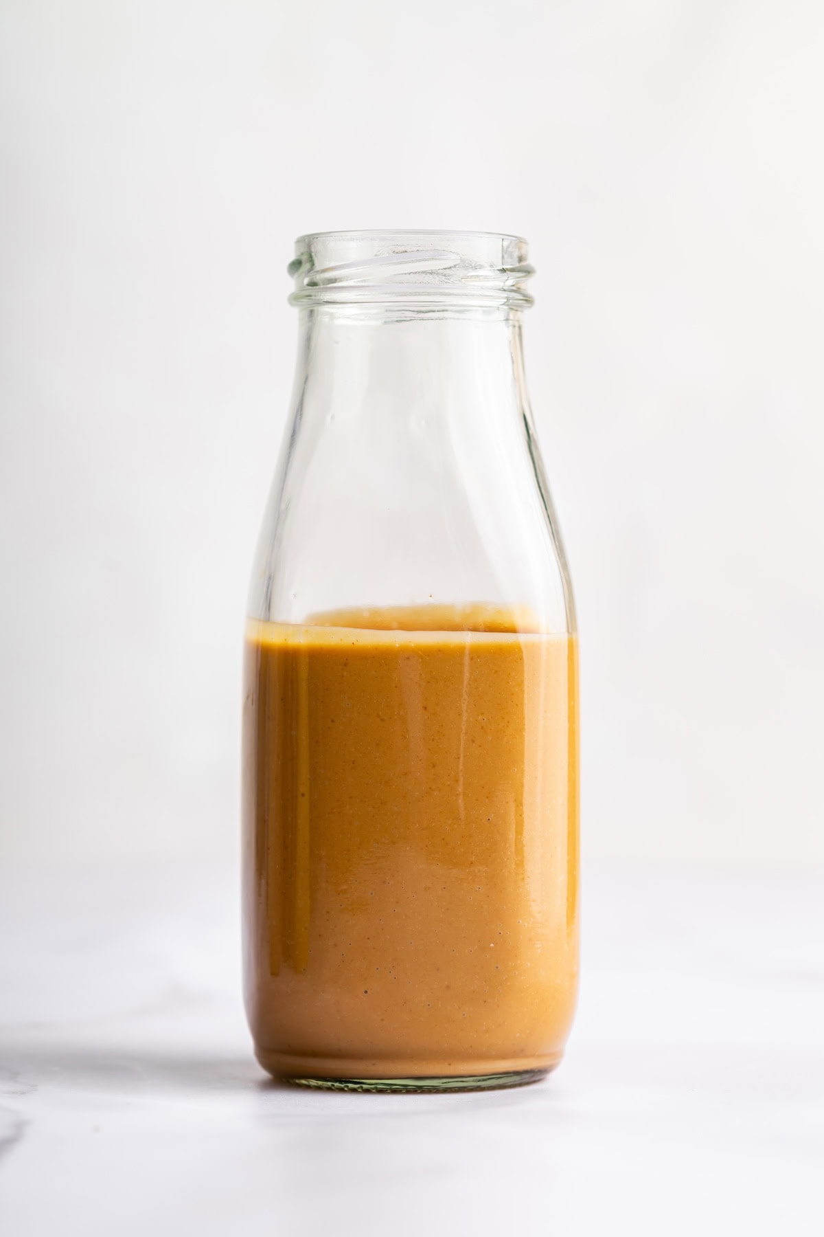 A peanut dressing in a glass bottle.