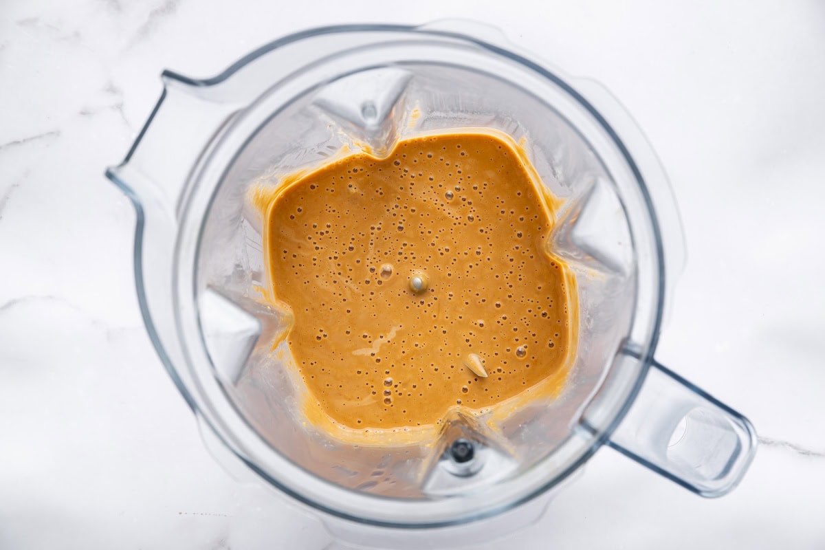 A peanut dressing in a blender after being blended.