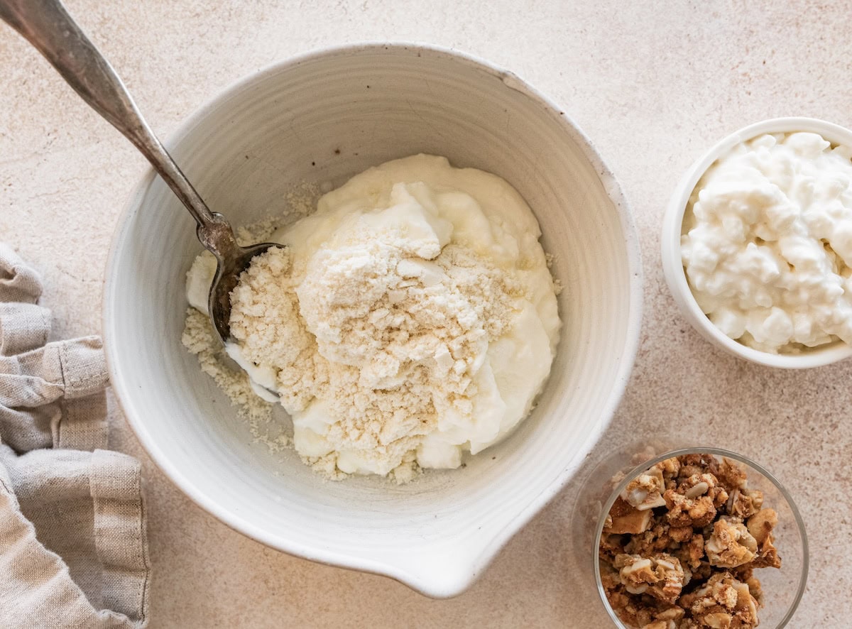 A large mixing bowl with protein powder, greek yogurt, and cottage cheese.