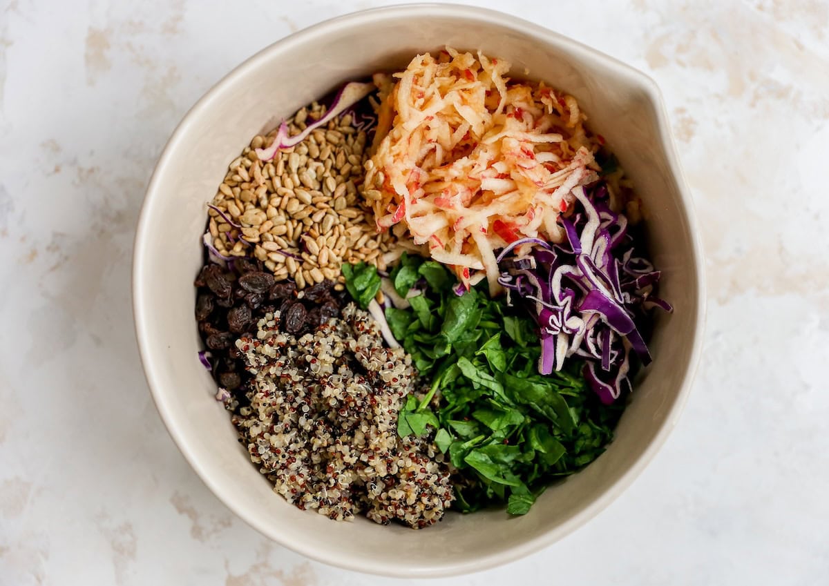 Ingredients used for an apple slaw in a large bowl before being combined.